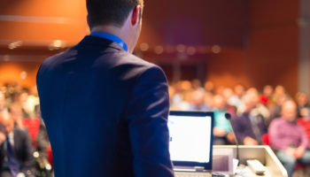 Corey Quinn speaking at a conference